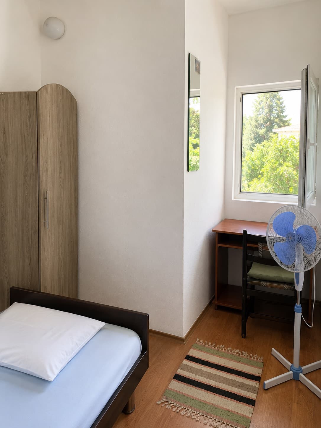 Soba sa ležajem, ormanom i stolom uz prozor